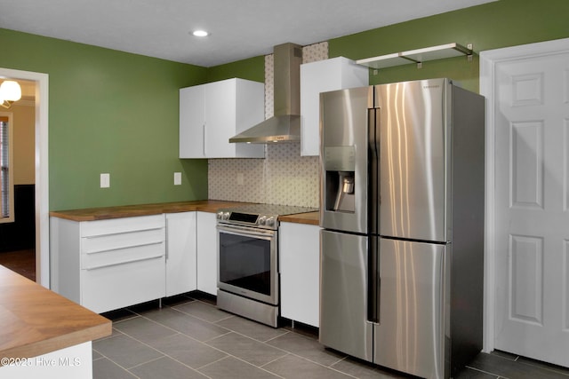 214 Target Ln, Hubert, NC 28539 - kitchen featuring appliances with stainless steel finishes, wall chimney exhaust hood, butcher block counters, white cabinets, and dark tile patterned floors
