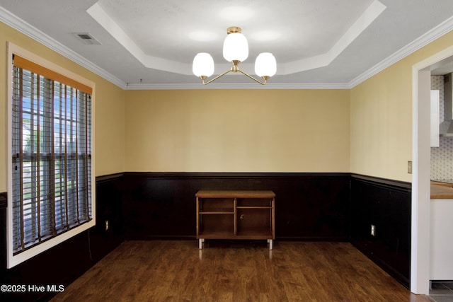 214 Target Ln, Hubert, NC 28539 - spare room featuring a raised ceiling, a wainscoted wall, wood finished floors, a chandelier, and crown molding