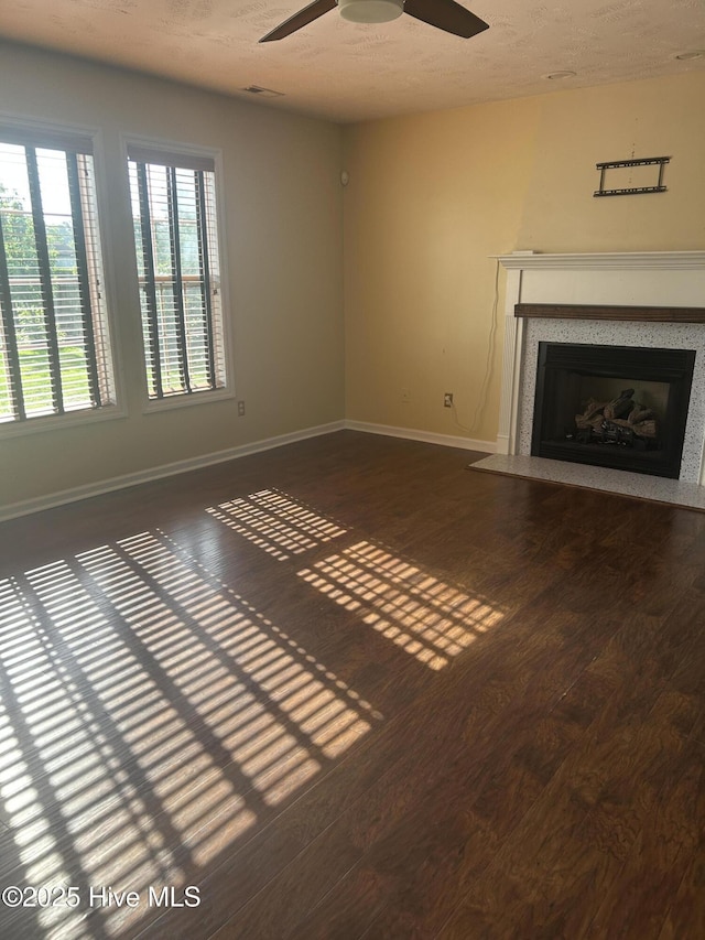 214 Target Ln, Hubert, NC 28539 - unfurnished living room with wood finished floors, a fireplace with flush hearth, ceiling fan, baseboards, and a textured ceiling