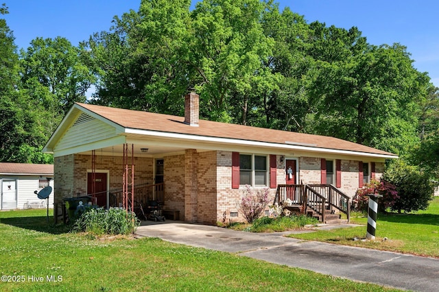 ranch-style home with a carport, a chimney, a front lawn, and brick siding