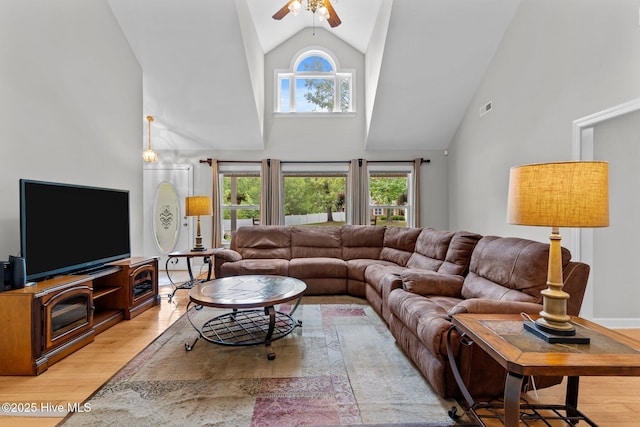 living area with light wood-style floors, visible vents, high vaulted ceiling, and ceiling fan