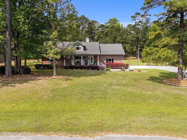 view of front of property featuring brick siding, a porch, a front lawn, and concrete driveway