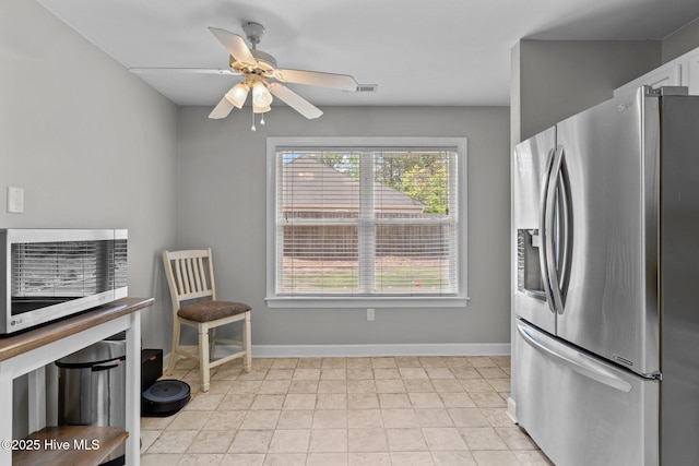 kitchen featuring white cabinetry, baseboards, ceiling fan, and stainless steel fridge with ice dispenser