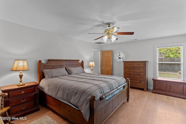 bedroom with ceiling fan, light wood finished floors, and visible vents