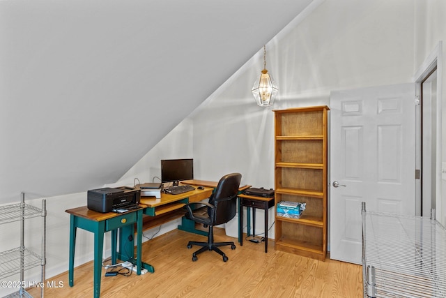 office space featuring lofted ceiling, wood finished floors, and baseboards