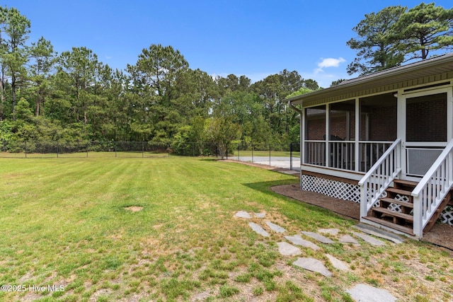 view of yard with a sunroom and fence