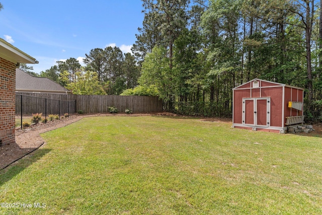 view of yard featuring a storage unit, an outbuilding, and a fenced backyard