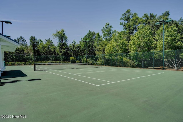 view of tennis court with fence and community basketball court