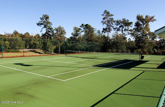 view of tennis court featuring community basketball court and fence