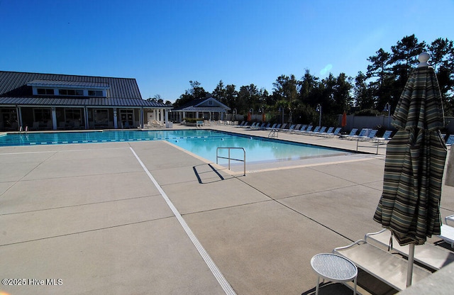 community pool featuring fence and a patio area