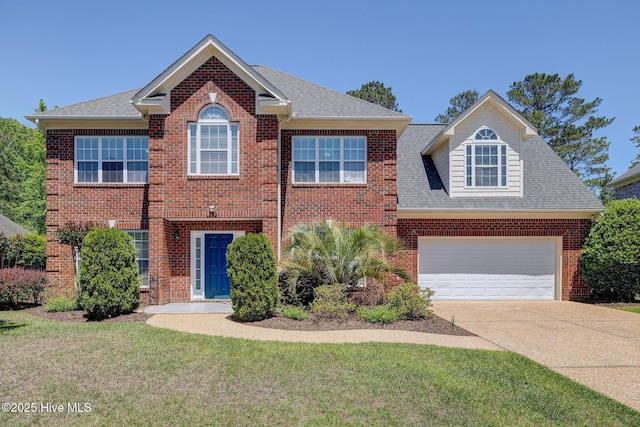 view of front of house with brick siding, a front lawn, roof with shingles, and driveway