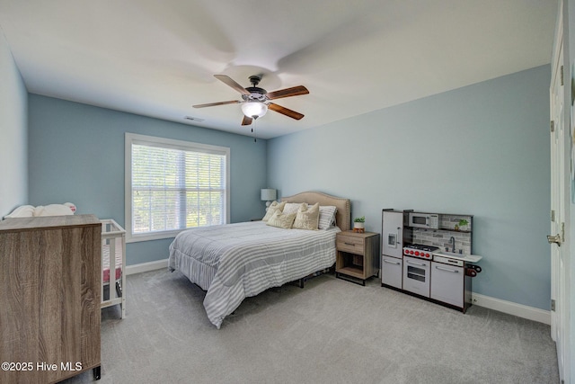 bedroom with baseboards, light colored carpet, ceiling fan, and visible vents