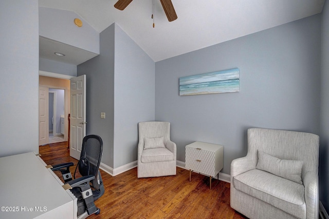 living area with baseboards, ceiling fan, wood finished floors, and lofted ceiling
