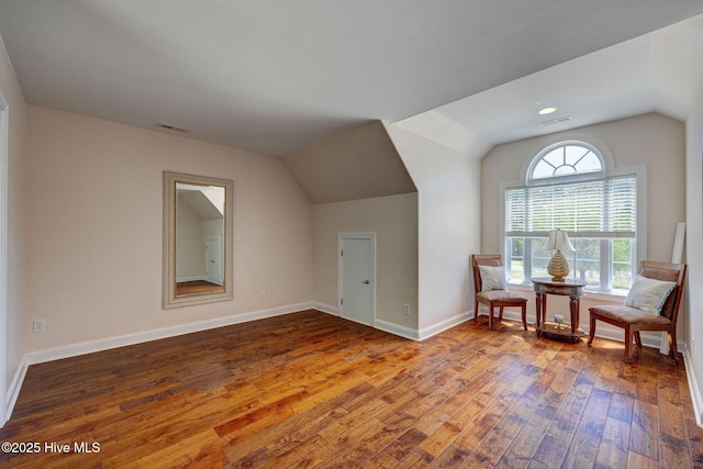 additional living space with visible vents, baseboards, lofted ceiling, and hardwood / wood-style flooring