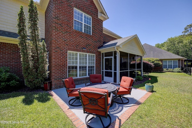 exterior space featuring a yard, brick siding, a patio area, and a sunroom