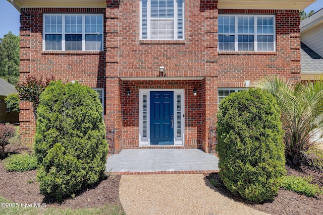 property entrance featuring brick siding