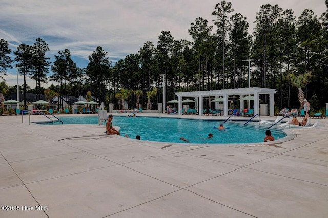 community pool with a pergola and a patio area