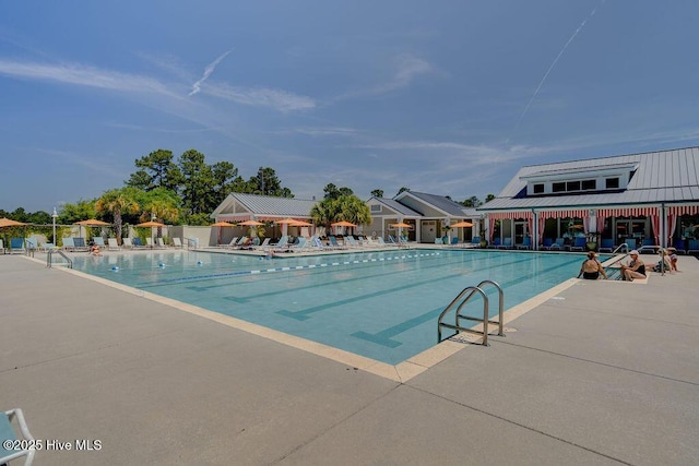 community pool with fence and a patio