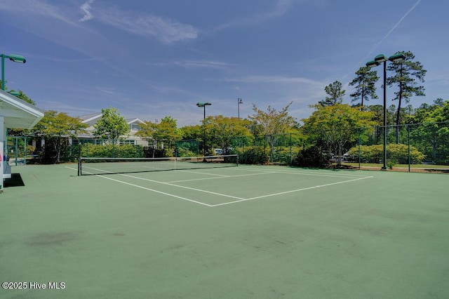 view of tennis court with community basketball court and fence