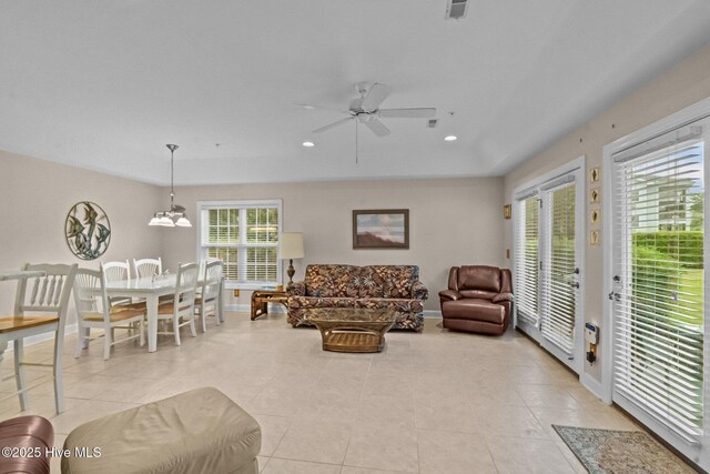 908 Resort Cir Unit 701, Sunset Beach, NC 28468 - living room featuring ceiling fan with notable chandelier, baseboards, visible vents, and light tile patterned flooring