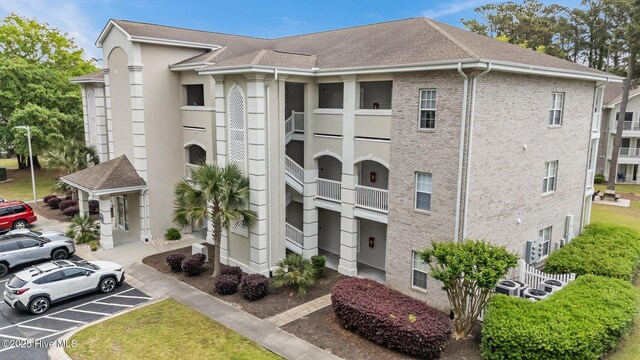 908 Resort Cir Unit 701, Sunset Beach, NC 28468 - view of building exterior with uncovered parking
