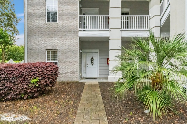 908 Resort Cir Unit 701, Sunset Beach, NC 28468 - doorway to property featuring brick siding and a balcony