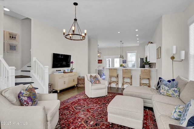 living area with recessed lighting, stairs, wood finished floors, and a chandelier