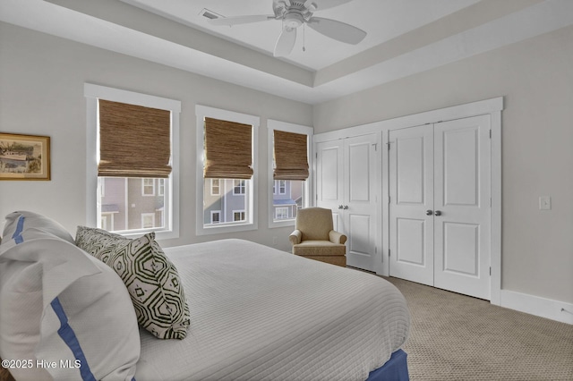 carpeted bedroom with multiple closets, multiple windows, ceiling fan, and visible vents
