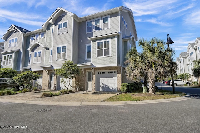 multi unit property with a garage, concrete driveway, and brick siding