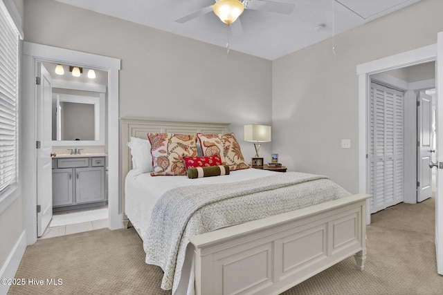 bedroom with ensuite bathroom, light carpet, a sink, and attic access