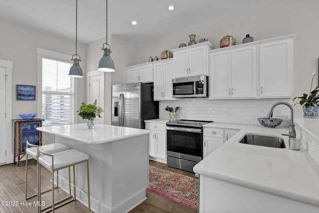 kitchen featuring a sink, decorative backsplash, stainless steel appliances, and white cabinets