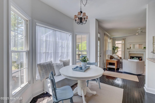 7240 Orchard Trce, Wilmington, NC 28409 - dining space featuring baseboards, ceiling fan with notable chandelier, dark wood-style flooring, and a fireplace