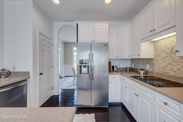 7240 Orchard Trce, Wilmington, NC 28409 - kitchen featuring dark wood-style floors, stainless steel appliances, arched walkways, and white cabinetry