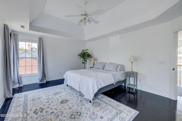 7240 Orchard Trce, Wilmington, NC 28409 - bedroom with visible vents, ceiling fan, a tray ceiling, baseboards, and dark wood-style flooring