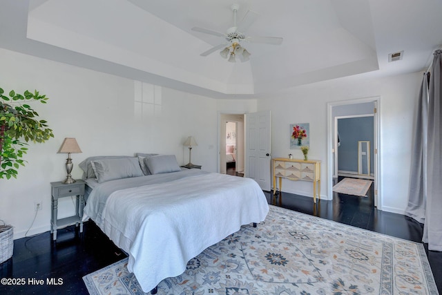 7240 Orchard Trce, Wilmington, NC 28409 - bedroom featuring ceiling fan, dark wood-type flooring, a tray ceiling, visible vents, and baseboards
