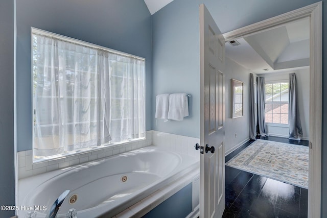 7240 Orchard Trce, Wilmington, NC 28409 - bathroom featuring a tub with jets, wood finished floors, baseboards, visible vents, and lofted ceiling