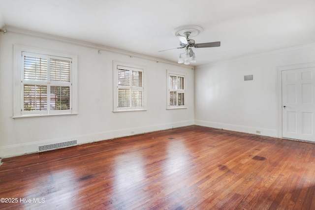 spare room featuring ceiling fan, visible vents, wood finished floors, and ornamental molding