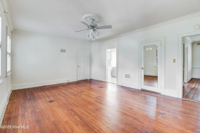 unfurnished room with ornamental molding, wood-type flooring, ceiling fan, and visible vents