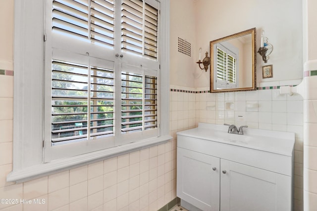 bathroom with tile walls, visible vents, and vanity