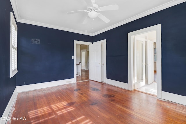 unfurnished bedroom with crown molding, a ceiling fan, wood finished floors, and baseboards