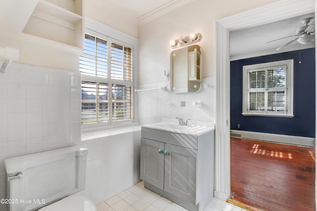 half bathroom with a wealth of natural light, ornamental molding, vanity, and ceiling fan