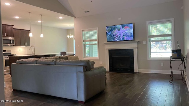 112 Schever Rd, West End, NC 27376 - living area featuring vaulted ceiling, dark wood-style flooring, a fireplace with flush hearth, recessed lighting, and baseboards