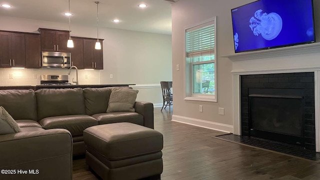 112 Schever Rd, West End, NC 27376 - living room with dark wood-type flooring, recessed lighting, a fireplace with flush hearth, and baseboards