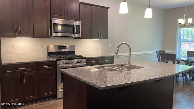 112 Schever Rd, West End, NC 27376 - kitchen featuring appliances with stainless steel finishes, a sink, wood finished floors, dark stone counters, and decorative backsplash