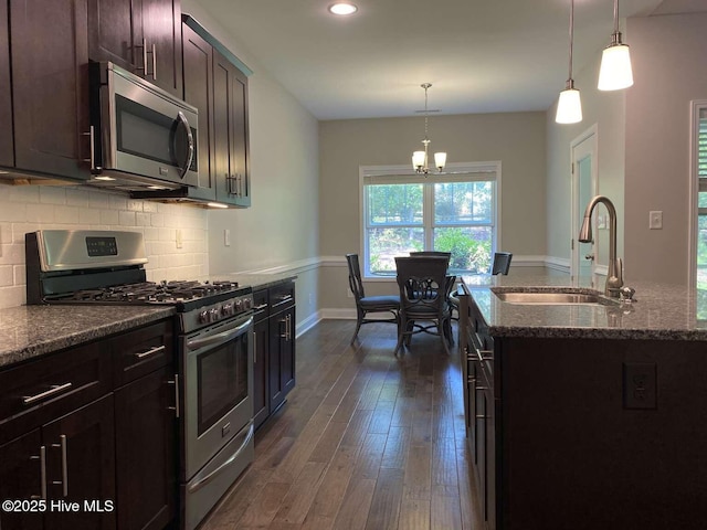 112 Schever Rd, West End, NC 27376 - kitchen featuring appliances with stainless steel finishes, a sink, dark wood-type flooring, a chandelier, and dark stone countertops