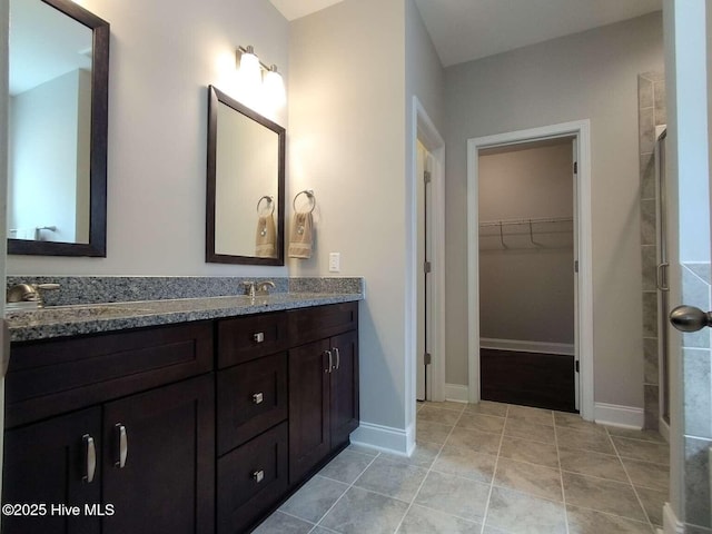 112 Schever Rd, West End, NC 27376 - full bath with double vanity, a walk in closet, tile patterned flooring, and baseboards