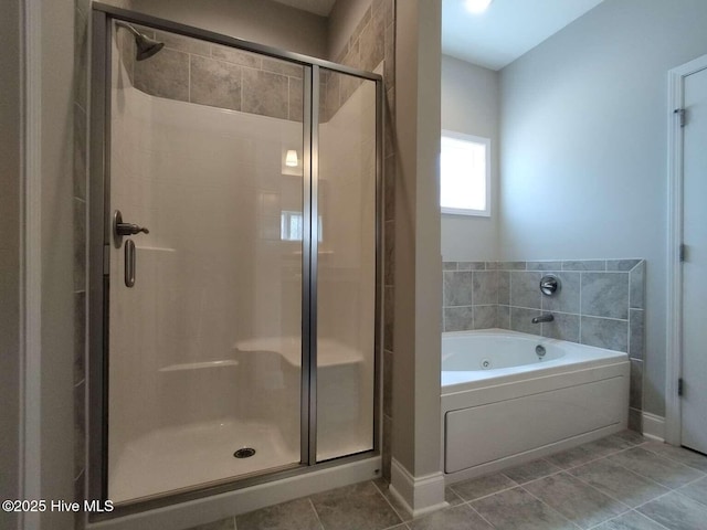 112 Schever Rd, West End, NC 27376 - full bathroom featuring a jetted tub, a shower stall, tile patterned floors, and baseboards