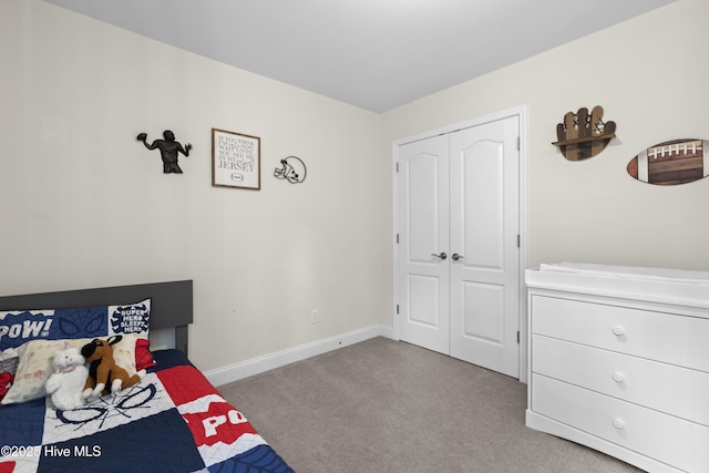 bedroom with light colored carpet, baseboards, and a closet