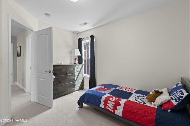 bedroom with visible vents and light carpet