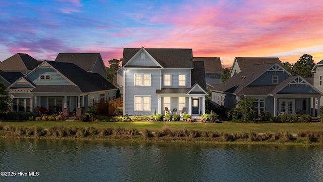 view of front facade featuring a water view and a lawn